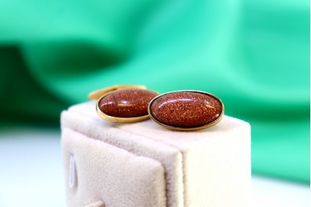  Botões de punho em ouro com pedra ovalizada em tom de castanho.